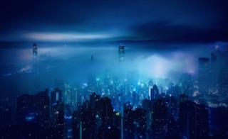 Energieverteiltechnik - Energieinfrastruktur für Industrie und Gewerbe - Wir planen und errichten die Energieinfrastruktur für industrieelle und gewerbliche Facilities - Nachtaufnahme Skyline Hong Kong, Blickrichtung Hafen, Wolken und Nebel verschleiern die Hochhäuser