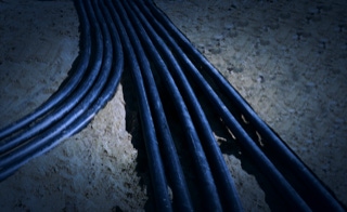 Leistungen - Kabelverlegung - Wir verlegen Kabel jeden Querschnitts - Baugrube mit Oberarm dicken Niederspannungskabeln auf gelblichem Sand