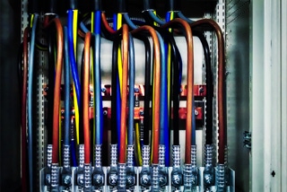 Niederspannungsschrankanlage mit verschraubten Pressverschluessen fingerdicker Kabeladern - Projekt Produktionsanlage Solarlux - Innenleben Niederspannungsschrankanlage mit verschraubten Pressverschluessen fingerdicker, senkrecht von oben ankommender,  brauner, blauer, schwarzer und gruen-gelber Kabeladern - Projekt Produktionsanlage Solarlux