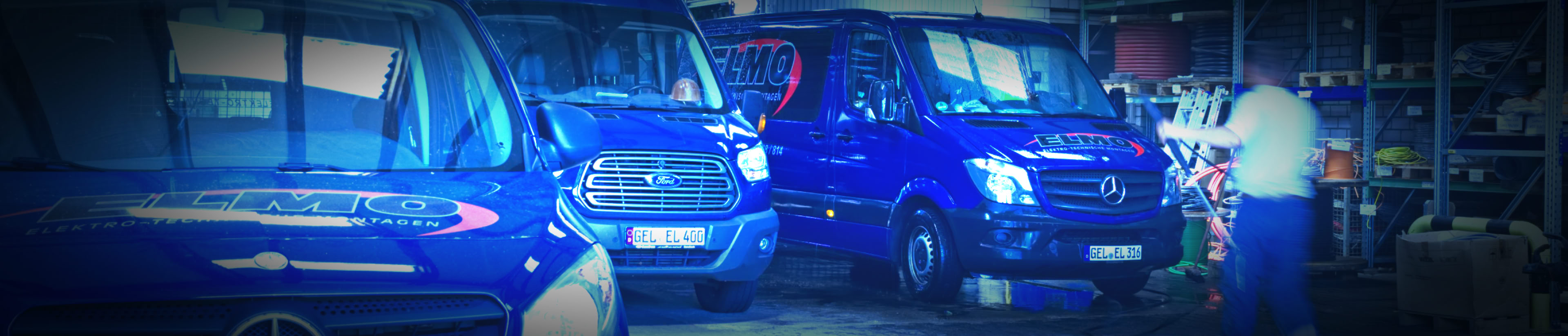 Foto  von drei blauen Team-Bussen in Betriebshalle, werden von Mitarbeiter gewaschen