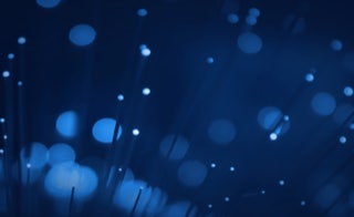 Leistungen - Datennetzwerke - Wir verlegen Lichtwellenleiter - Nahaufnahme von lichtleitenden Glasfaserenden, wenig Tiefenschärfe, viel Bokeh